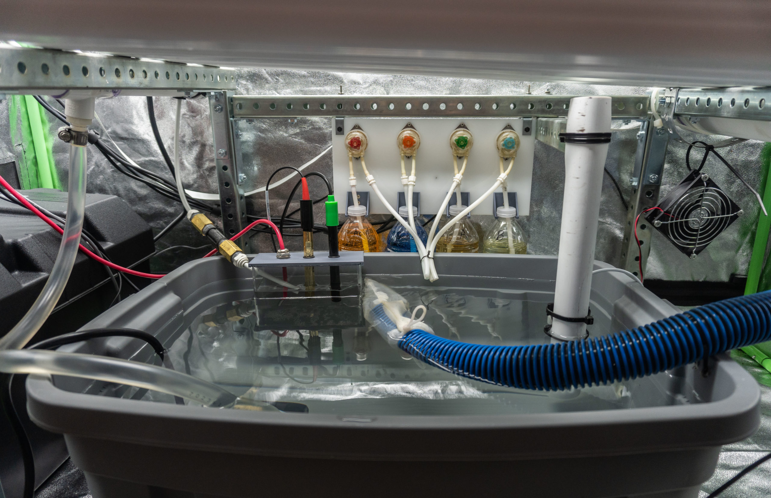 Side view of the hydroponic setup with reservoir and tubing
